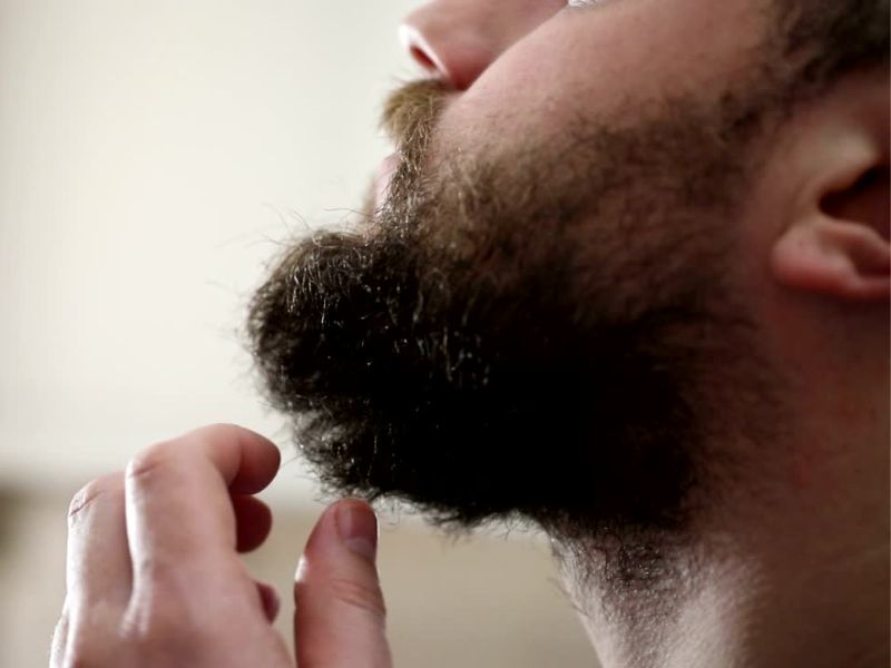 Čovek stavlja ulje na bradu