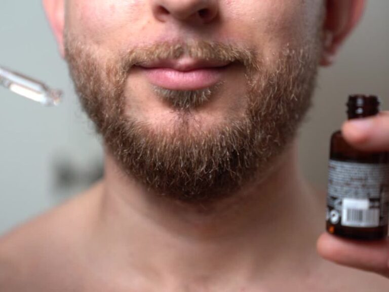 muškarac stavlja ulje na bradu