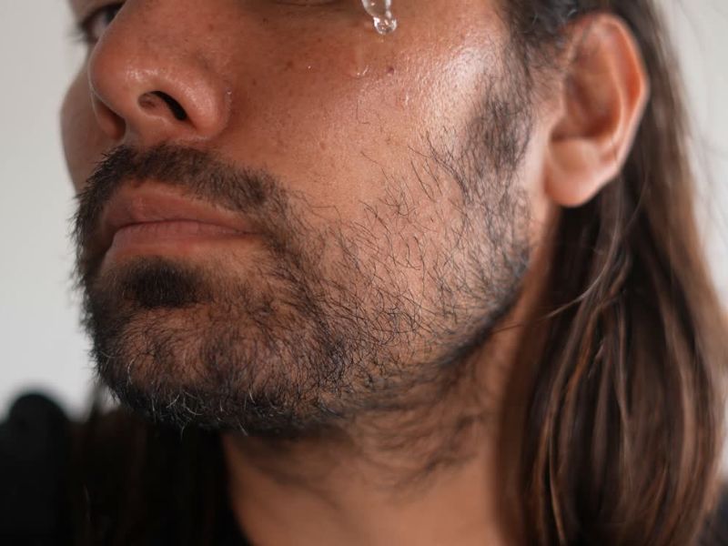 Čovek nanosi ulje na bradu