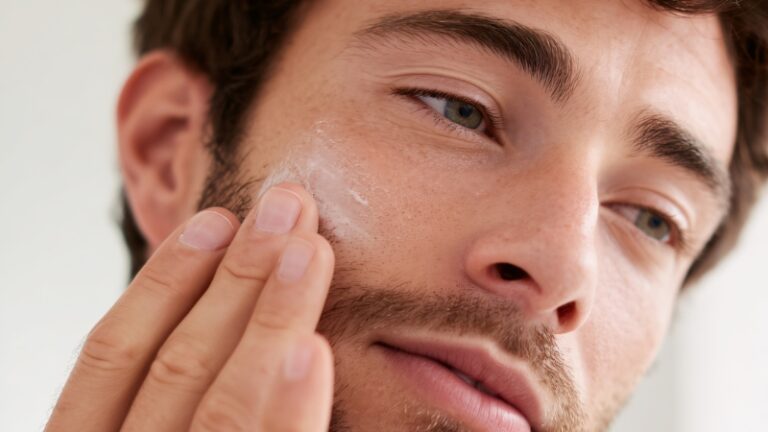 Muškarac nanosi kremu na lice kao deo nege